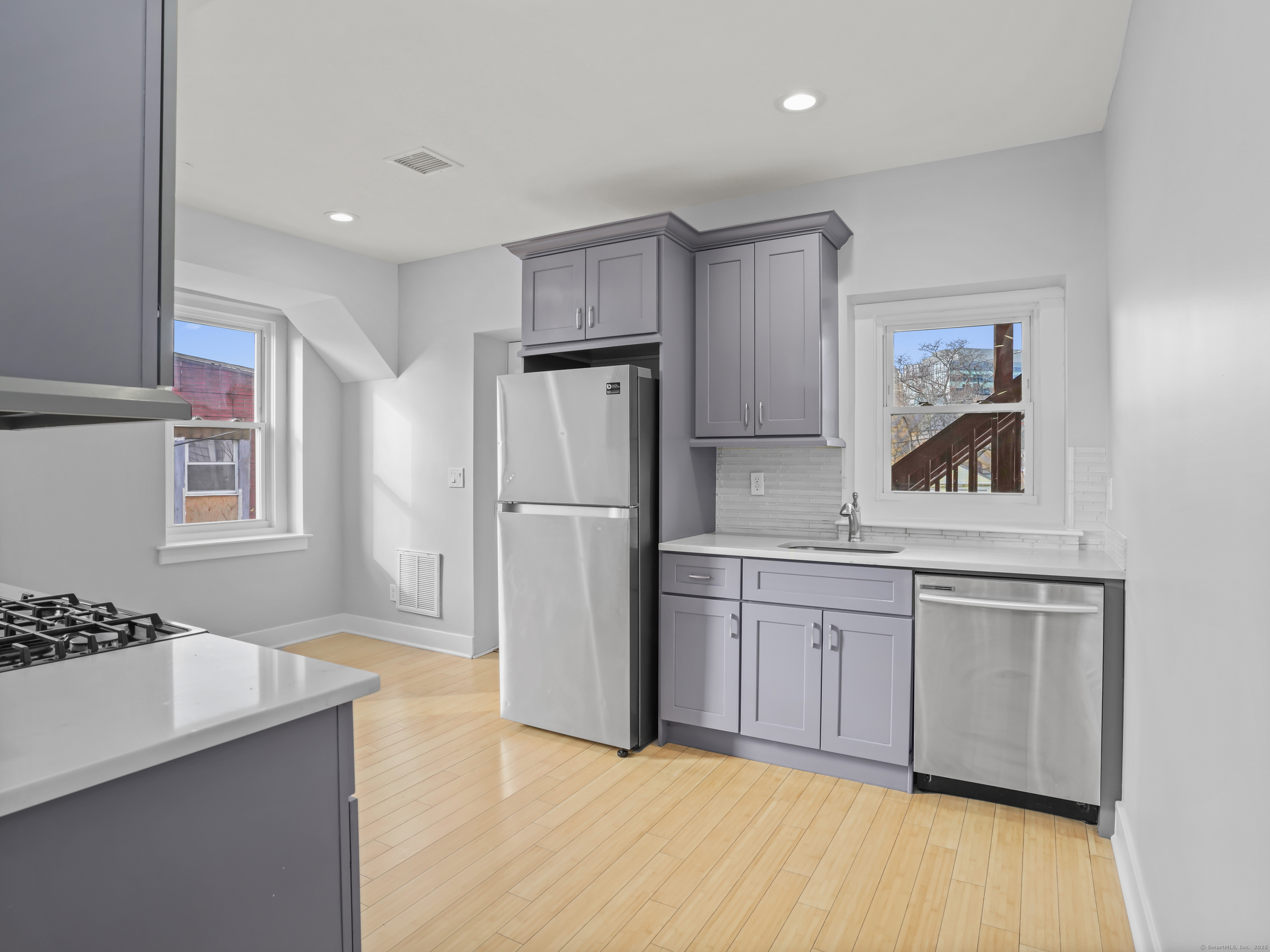 775 Atlantic Street, Unit R2 Stamford, CT 06902 - Photo 2 of 18 a kitchen with refrigerator cabinets and wooden floor