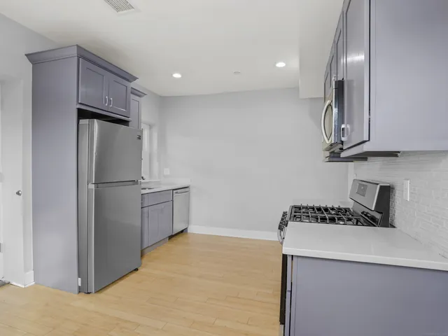 a kitchen with stainless steel appliances a refrigerator and a stove top oven