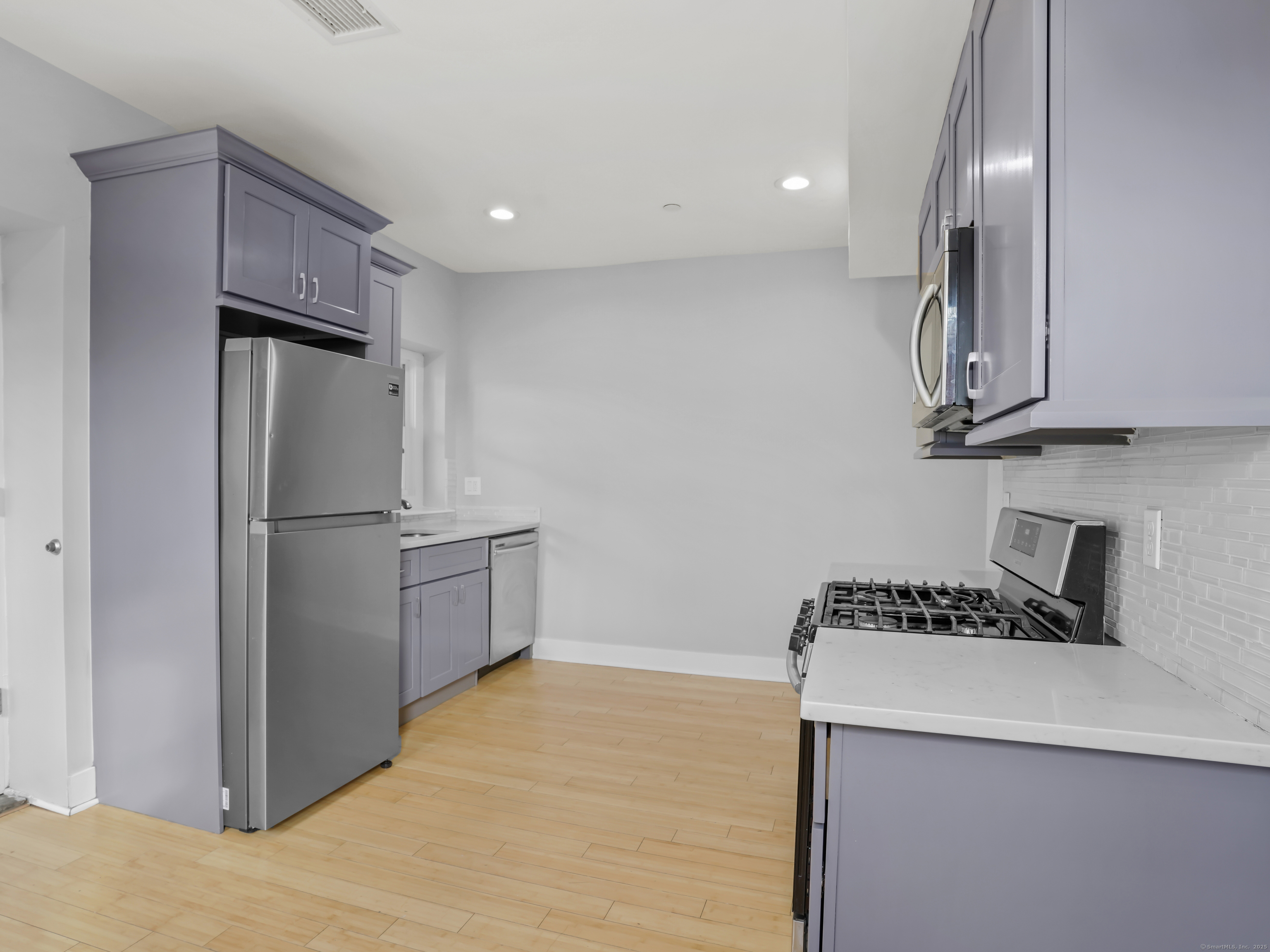 775 Atlantic Street, Unit R2 Stamford, CT 06902 - Photo 4 of 18 a kitchen with stainless steel appliances a refrigerator and a stove top oven