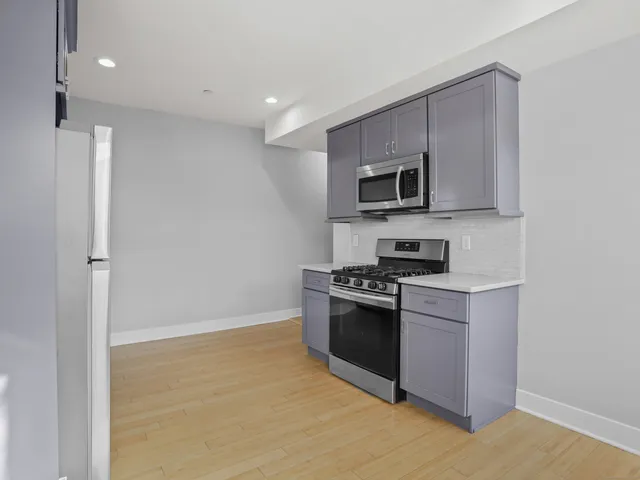 a kitchen with granite countertop a stove and a microwave oven