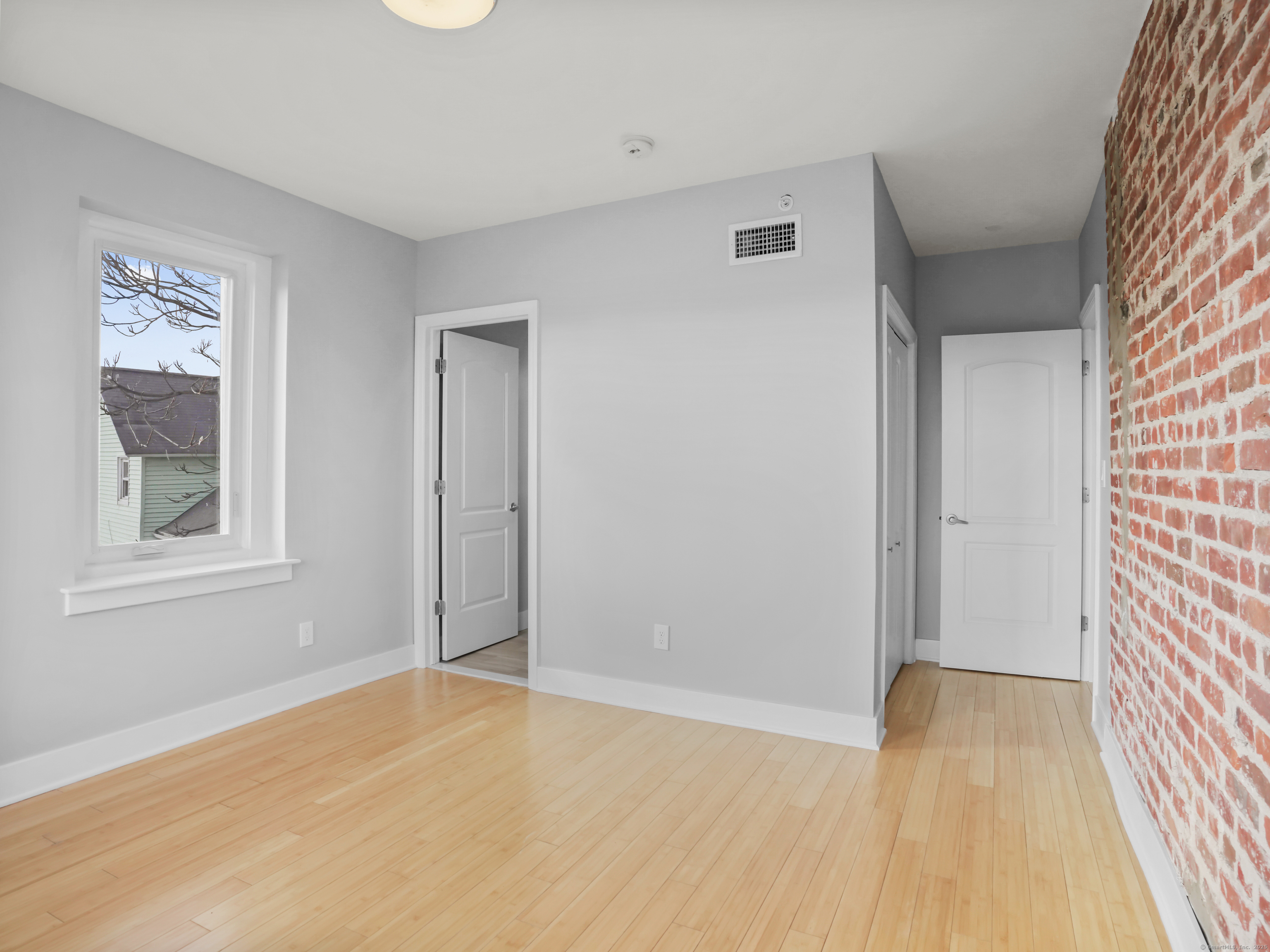 775 Atlantic Street, Unit R2 Stamford, CT 06902 - Photo 8 of 18 a view of an empty room with wooden floor and a window