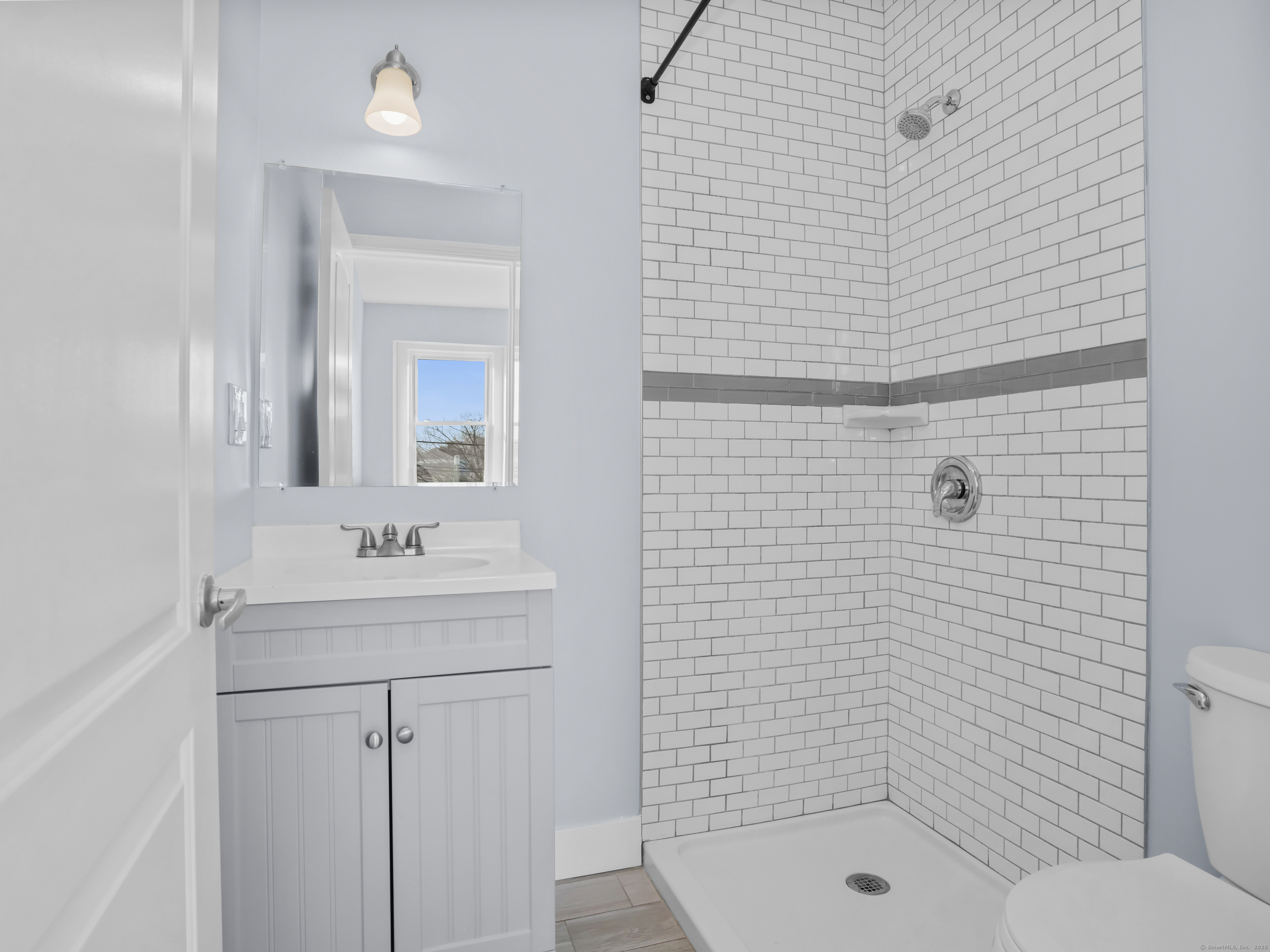 775 Atlantic Street, Unit R2 Stamford, CT 06902 - Photo 10 of 18 a bathroom with a shower a sink a toilet and mirror