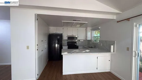 a kitchen with a sink dishwasher a refrigerator and wooden cabinets