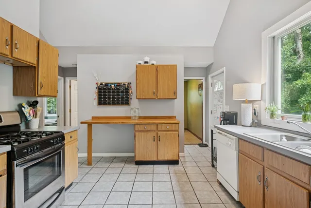 a kitchen with granite countertop a sink stove and cabinets