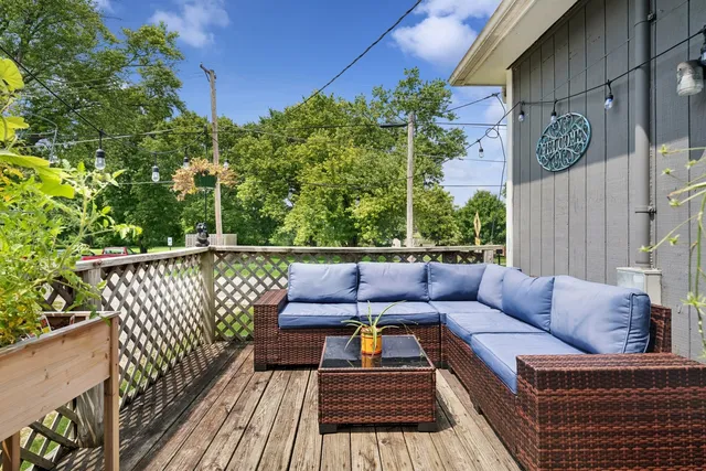 a balcony with wooden floor and outdoor seating