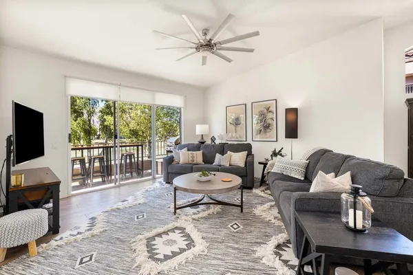 a living room with furniture a flat screen tv and a large window
