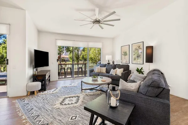 a living room with furniture a flat screen tv and a large window