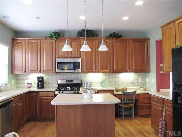 5443 Shaker Heights Lane Raleigh, NC 27613 - Photo 6 of 14 a kitchen with stainless steel appliances granite countertop a stove a sink a microwave a refrigerator and chairs