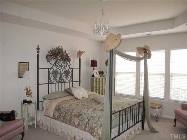 5443 Shaker Heights Lane Raleigh, NC 27613 - Photo 8 of 14 a bedroom with a large bed and a chandelier