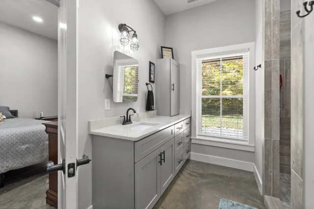 a bathroom with a sink a mirror and a bathtub next to a window