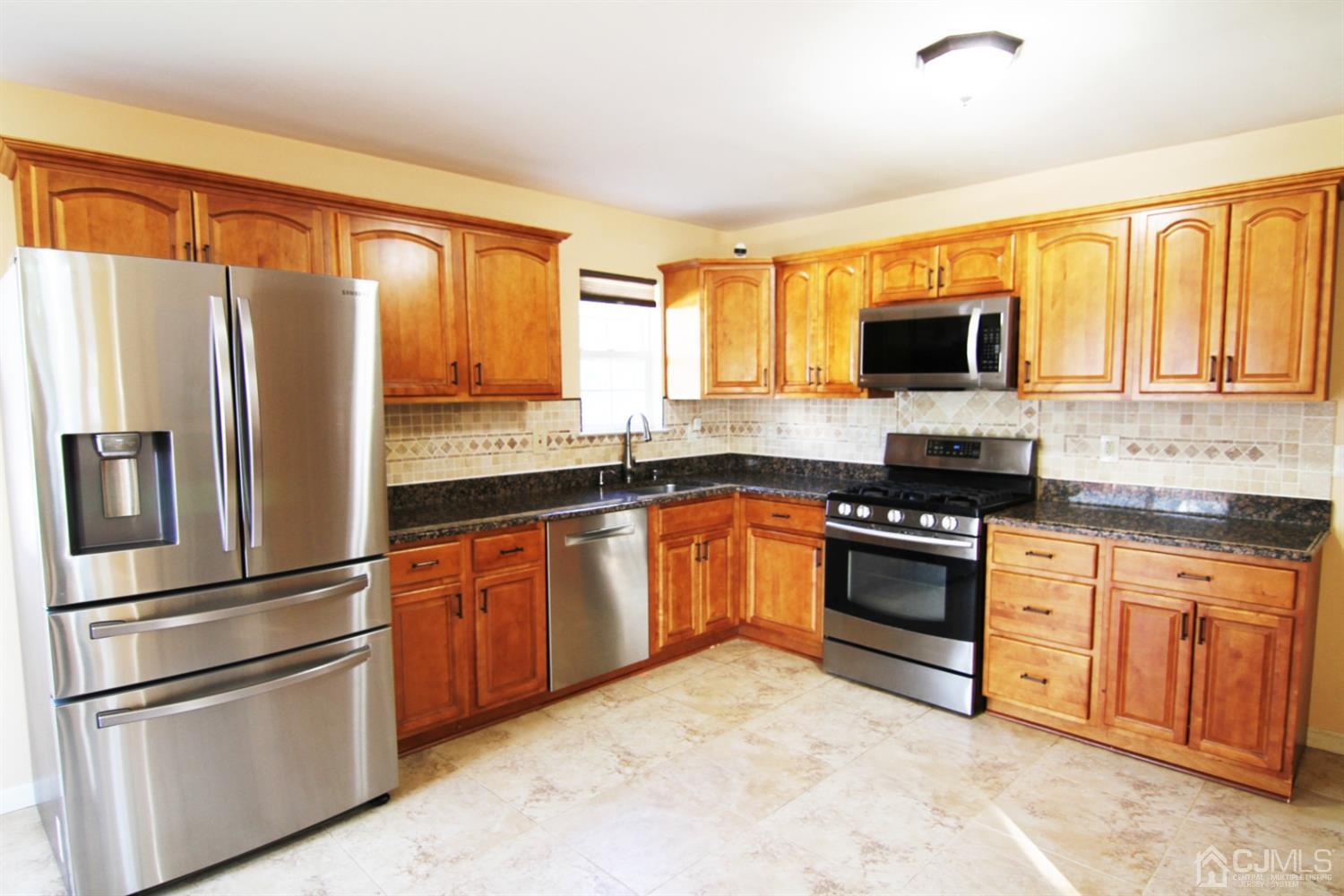 14 Pointer Place Kendall Park, NJ 08824 - Photo 16 of 34 a kitchen with stainless steel appliances granite countertop a refrigerator stove top oven a sink and dishwasher