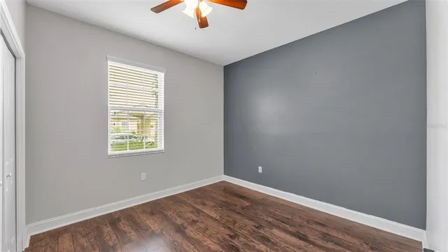 an empty room with a window and a ceiling fan