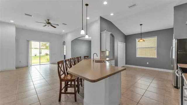 a kitchen with kitchen island a sink stainless steel appliances and a chandelier