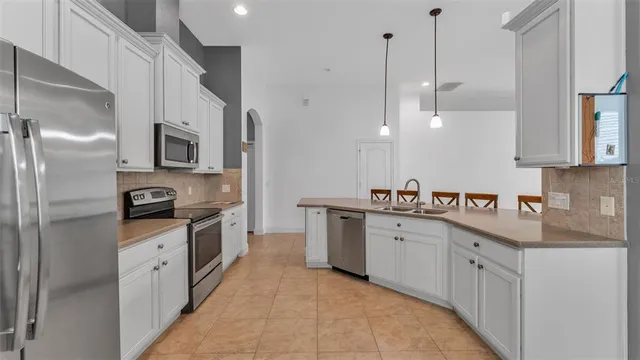 a kitchen with stainless steel appliances granite countertop a sink a stove and a refrigerator