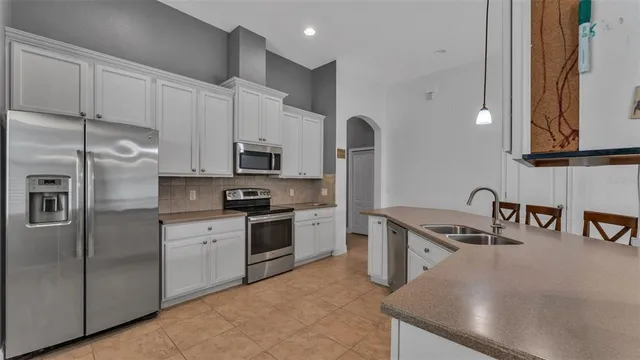 a kitchen with stainless steel appliances granite countertop a sink a stove and a refrigerator