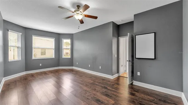 a view of an empty room with window and wooden floor