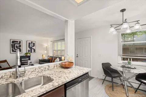 a kitchen with a granite countertop sink table and chairs
