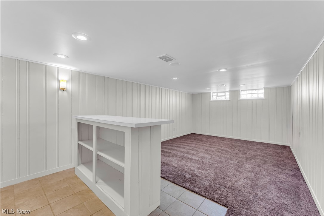 9716 Alexander Road Cleveland, OH 44125 - Photo 24 of 30 Below grade area with light tile patterned flooring, recessed lighting, light colored carpet, and wood walls