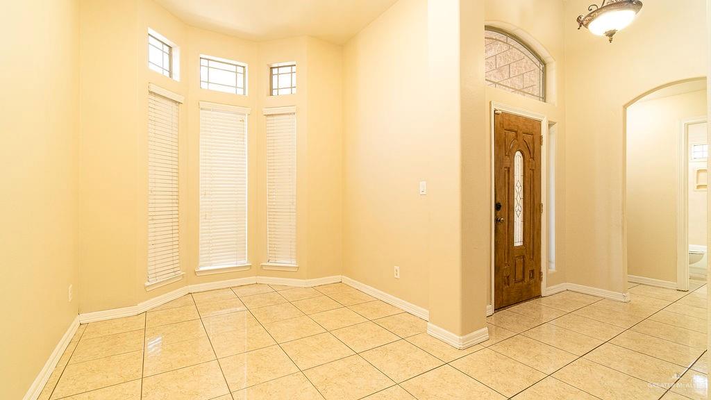 919 Hill Country Road Edinburg, TX 78539 - Photo 4 of 22 Entryway featuring a wood-panel door with decorative glass, an arched transom window, and a decorative ceiling light fixture