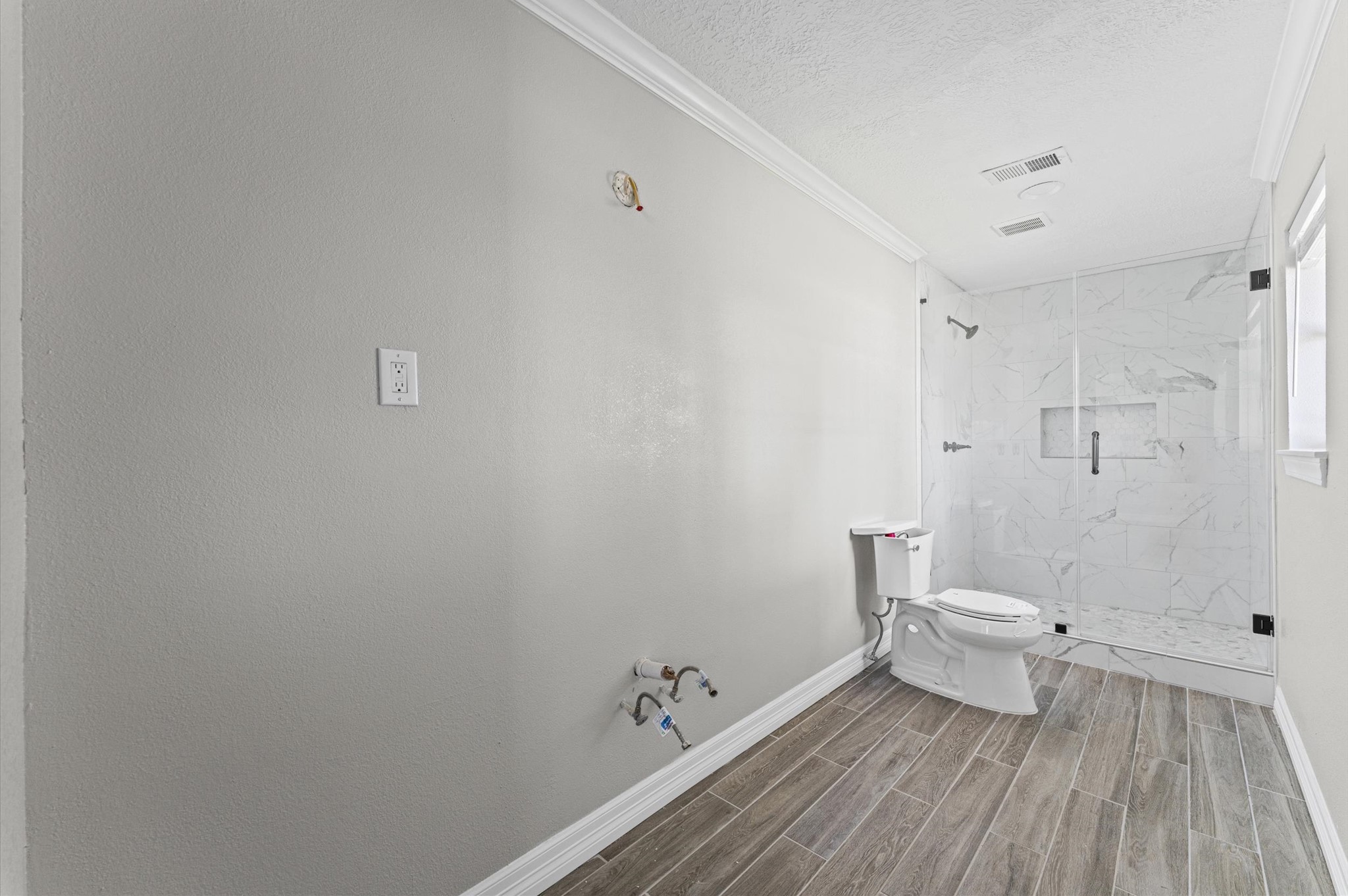2702 Crowell Lane Baytown, TX 77521 - Photo 19 of 26 a bathroom with a toilet and a wooden floor