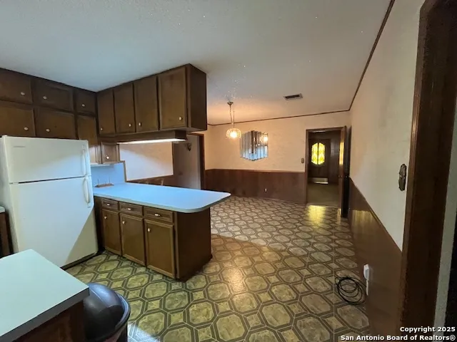 a kitchen with stainless steel appliances granite countertop a refrigerator a stove and a cabinets