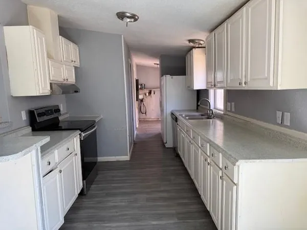 a kitchen with stainless steel appliances a sink stove and cabinets