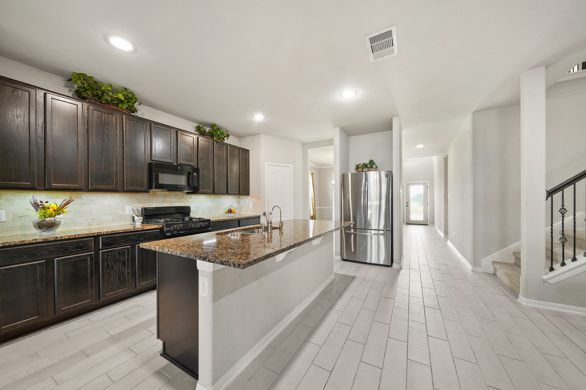 8802 Mallow Rose Way Rosharon, TX 77583 - Photo 10 of 29 This wonderful kitchen features tile floors, granite countertops, beautiful wood cabinets, stainless steel appliances, recessed lighting, a large island, and is open to the living and breakfast areas.