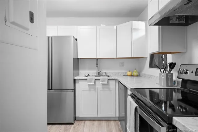a kitchen with stainless steel appliances a sink stove and refrigerator