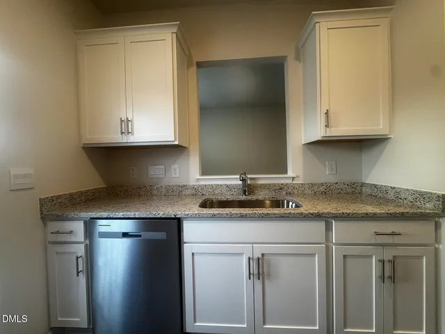 a kitchen with stainless steel appliances granite countertop white cabinets and a stove top oven