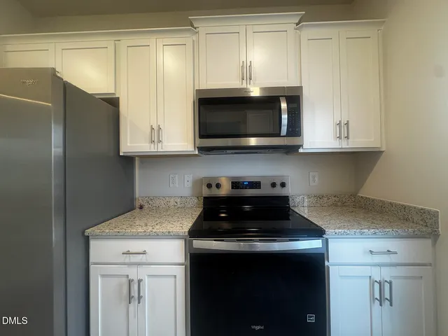 a white toilet sitting next to a white sink and vanity