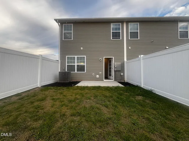 a view of a backyard with plants and large tree