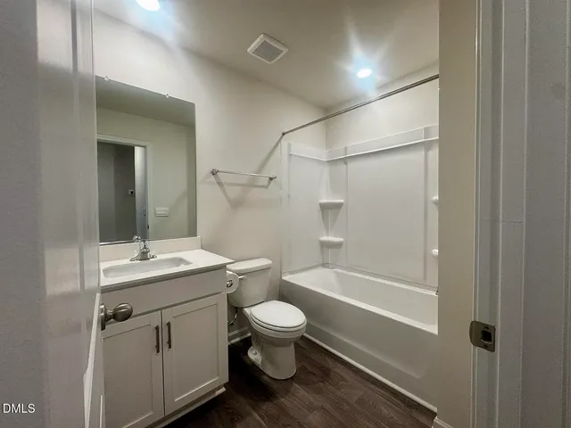 a bathroom with a sink toilet vanity and tub