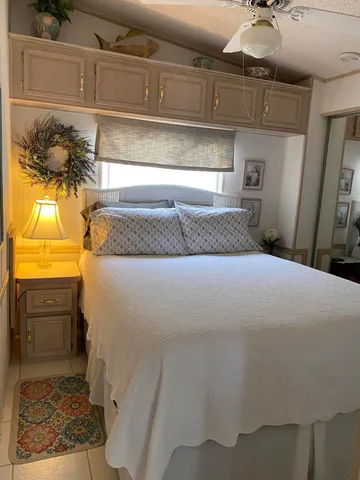 a bedroom with a bed and dresser with mirror