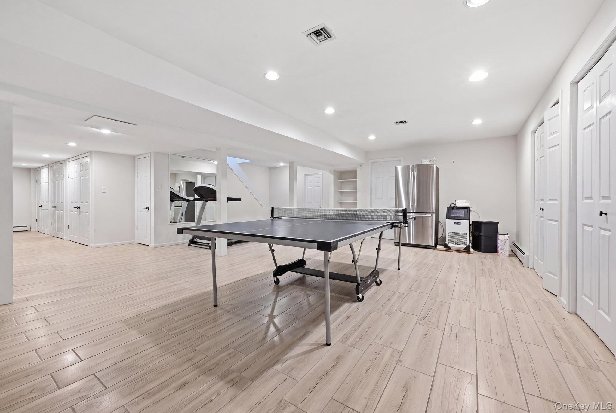19 Sunset Road West Albertson, NY 11507 - Photo 22 of 24 Spacious interior featuring light wood-finish flooring, recessed lighting, multiple storage closets with bifold doors, and a built-in shelving unit