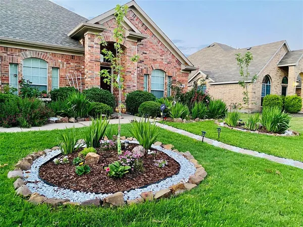 a view of a big house with a big yard and potted plants