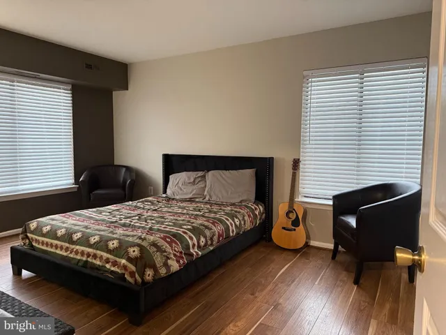 a bedroom with a bed and wooden floor
