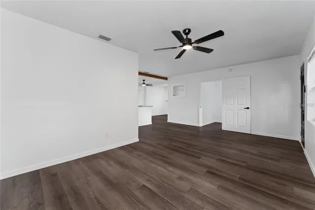 a view of empty room with wooden floor