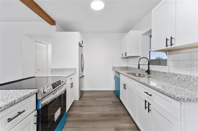 a kitchen with stainless steel appliances granite countertop a sink and a stove