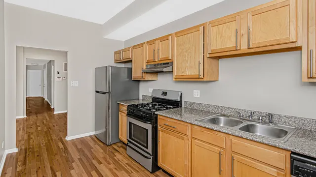 a kitchen with granite countertop a sink stove and refrigerator