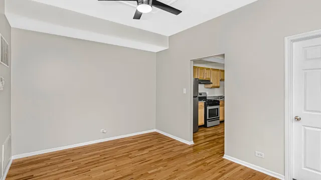 a view of empty room with wooden floor