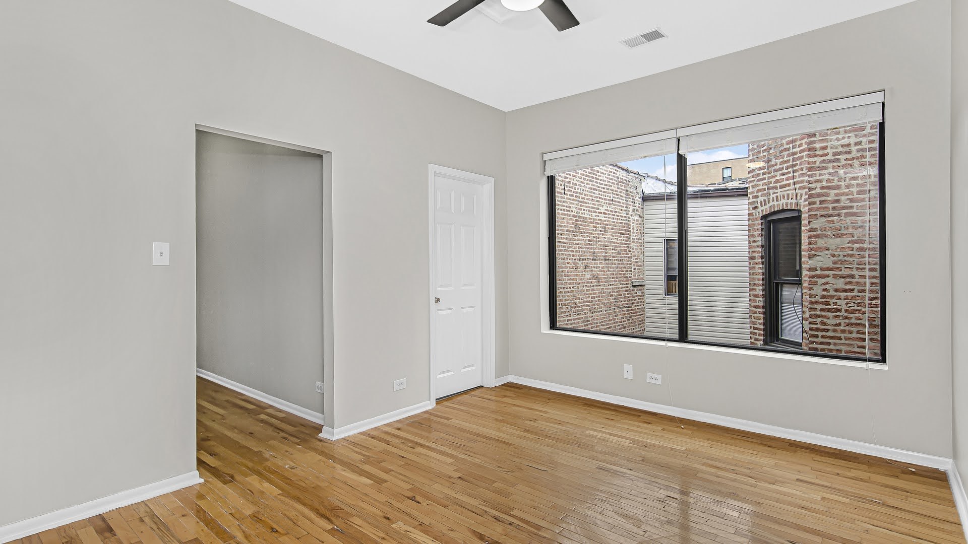 4055 South Calumet Avenue, Unit 3 Chicago, IL 60653 - Photo 6 of 15 a view of an empty room with a window and wooden floor