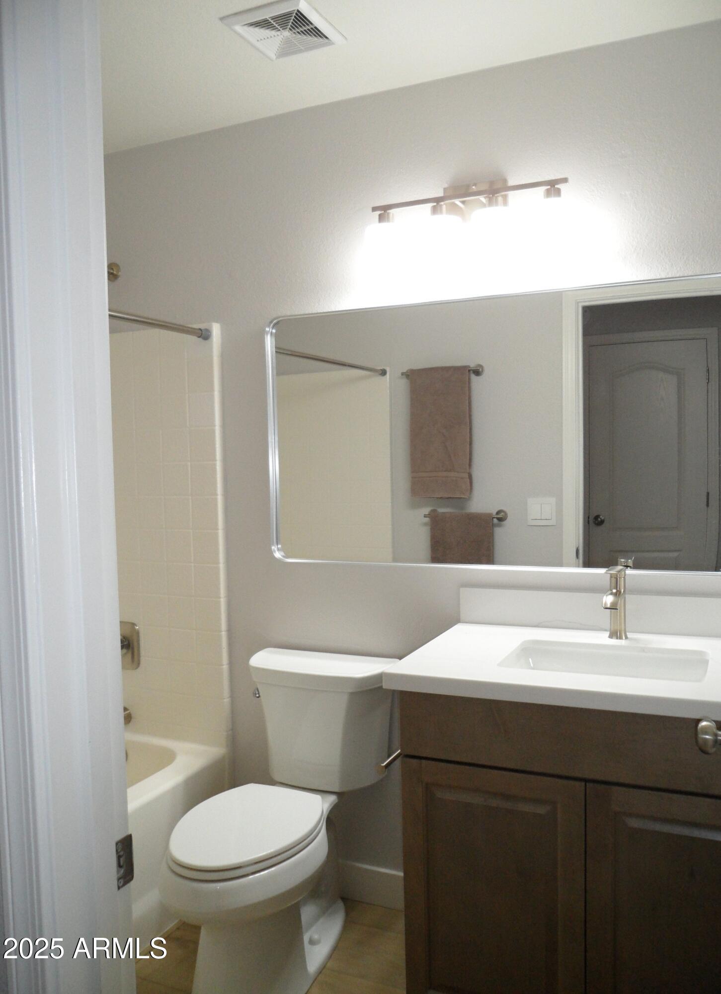 3812 South Seton Avenue Gilbert, AZ 85297 - Photo 13 of 18 a bathroom with a sink a toilet a mirror and vanity