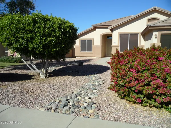 a front view of a house with a yard and a garden