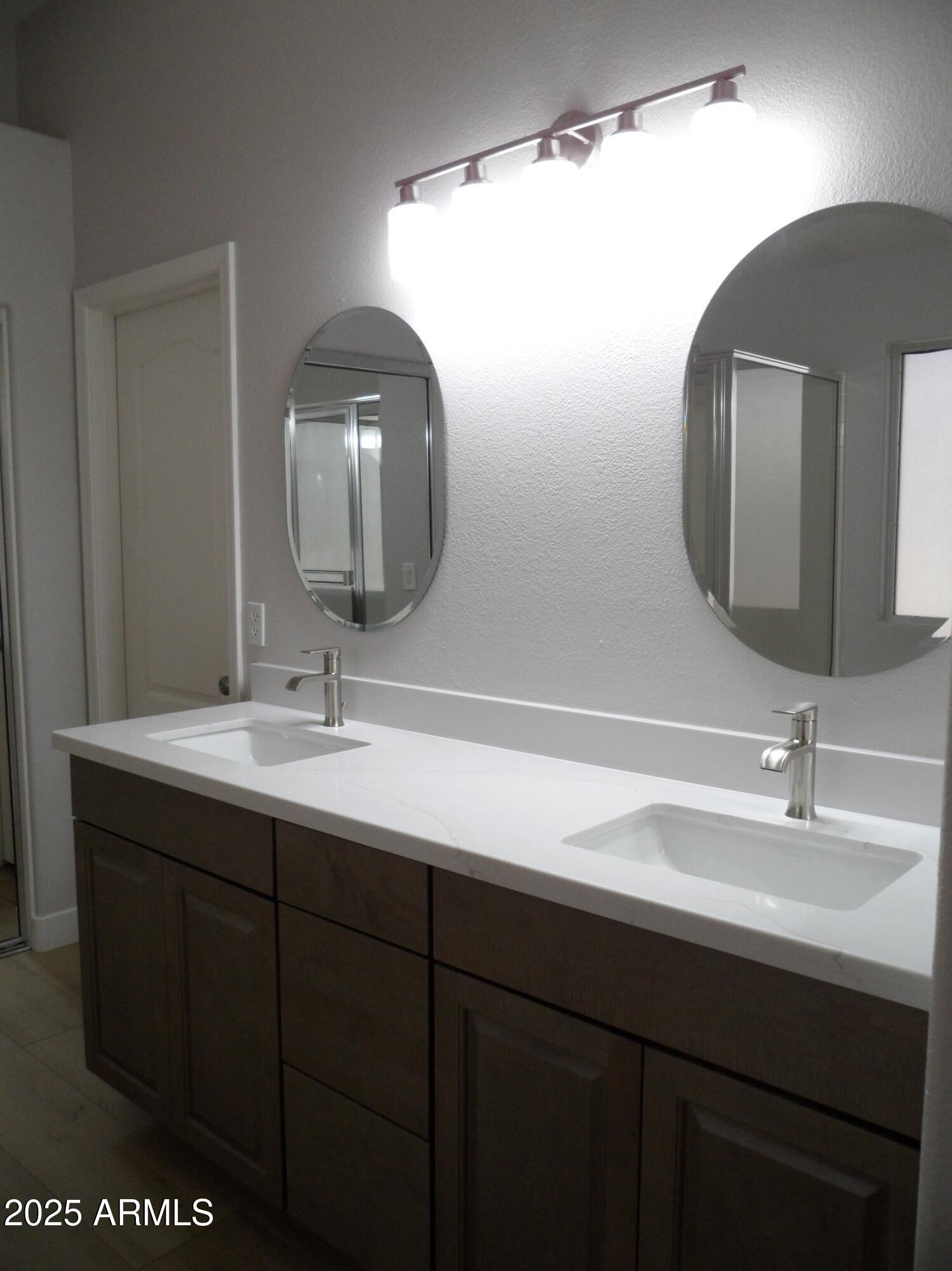 3812 South Seton Avenue Gilbert, AZ 85297 - Photo 9 of 18 a bathroom with a double vanity sink and a mirror