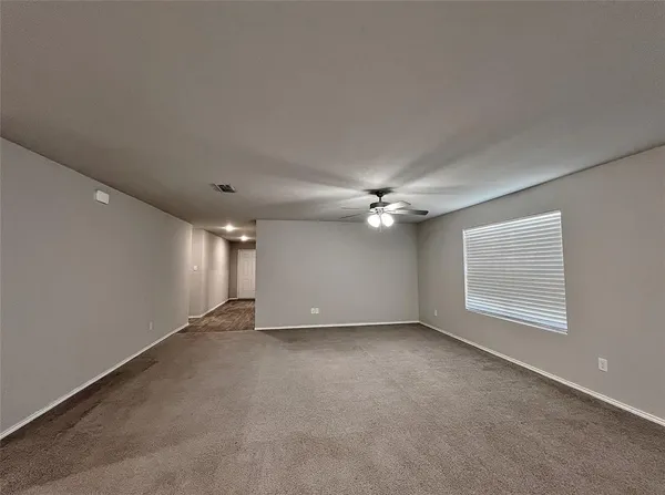 an empty room with windows and fan
