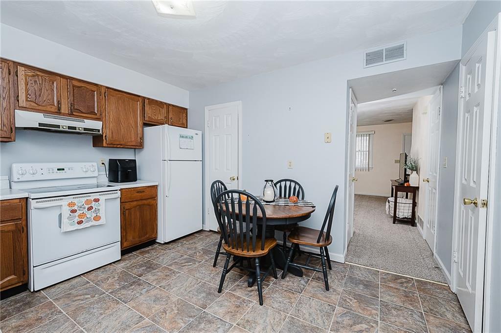 4852 Lucerne Road Indiana, PA 15701 - Photo 8 of 22 a kitchen with a dining table chairs and white appliances