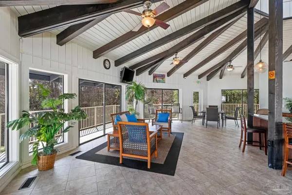 a living room with patio furniture and potted plants