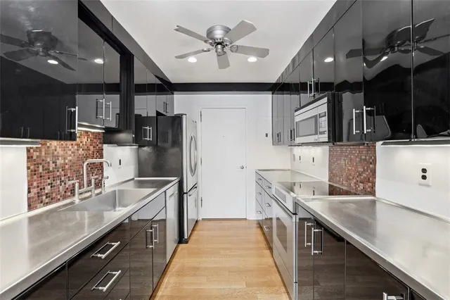 a kitchen with stainless steel appliances sink stove refrigerator and cabinets