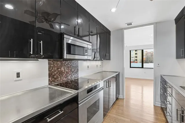 a kitchen with a sink and steel appliances