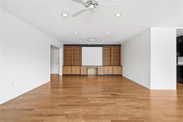 a view of an empty room with a window and wooden floor